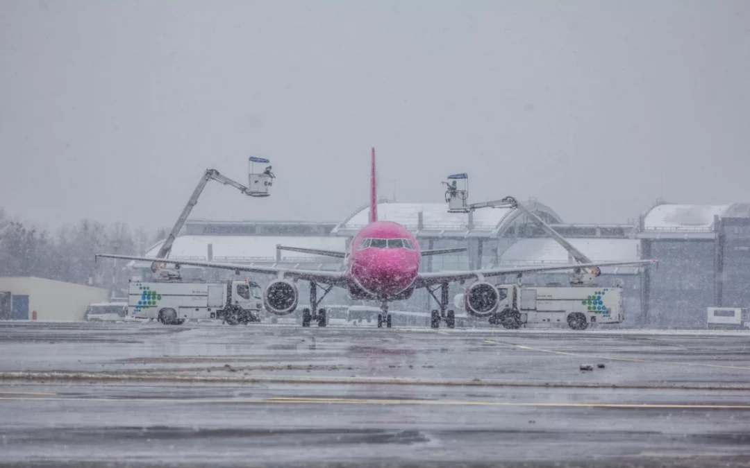 Vereistes Flugzeug wird im Winter von 2 Mitarbeitern des Flughafens enteist