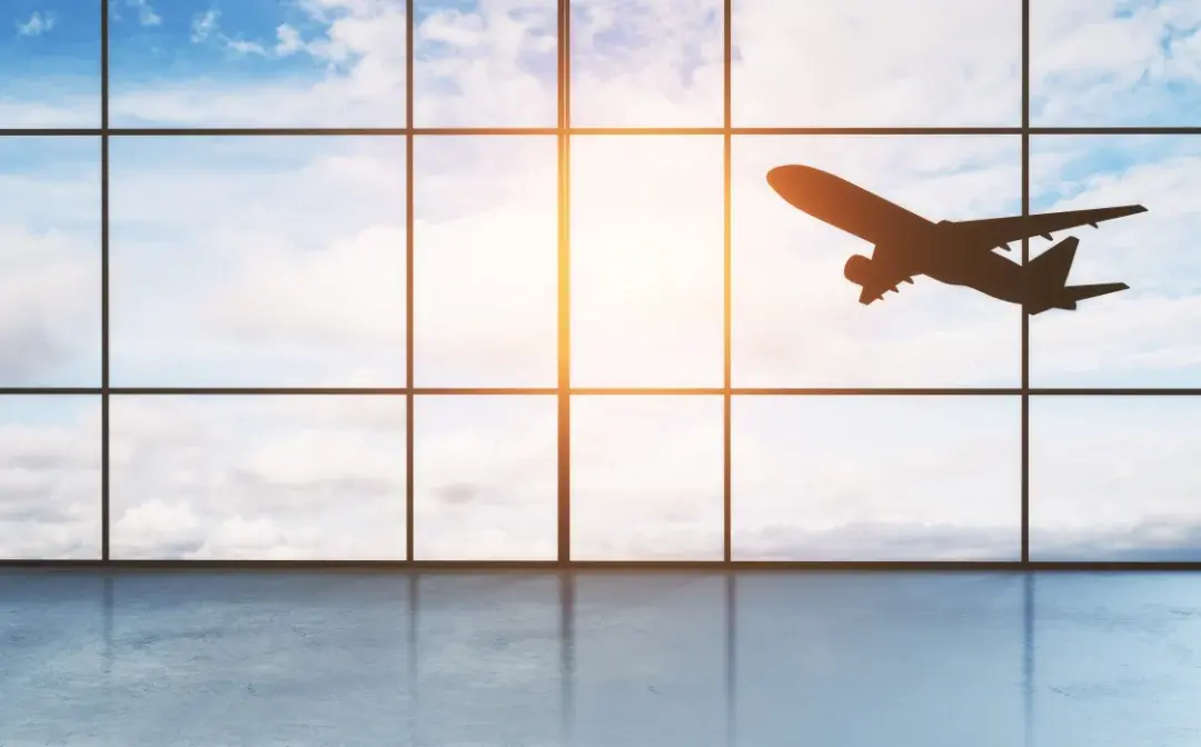 Flugzeug am gelbroten Abendhimmel. Sicht aus Flughafenterminal